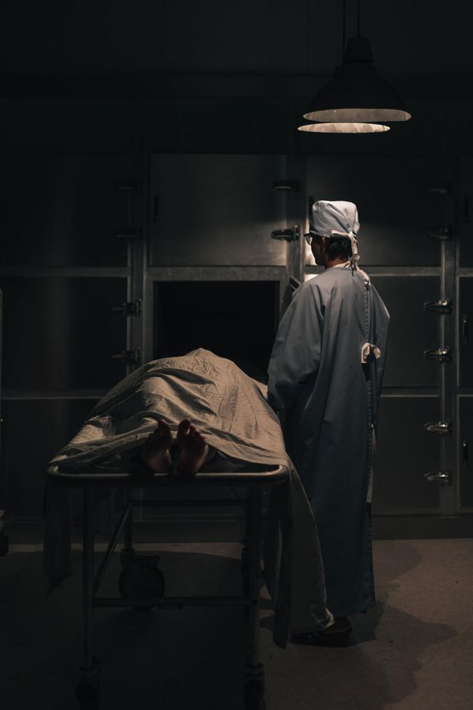 Image of Proper Ammo Storage - a doctor in scrubs puts a corpse into a mortuary freezer